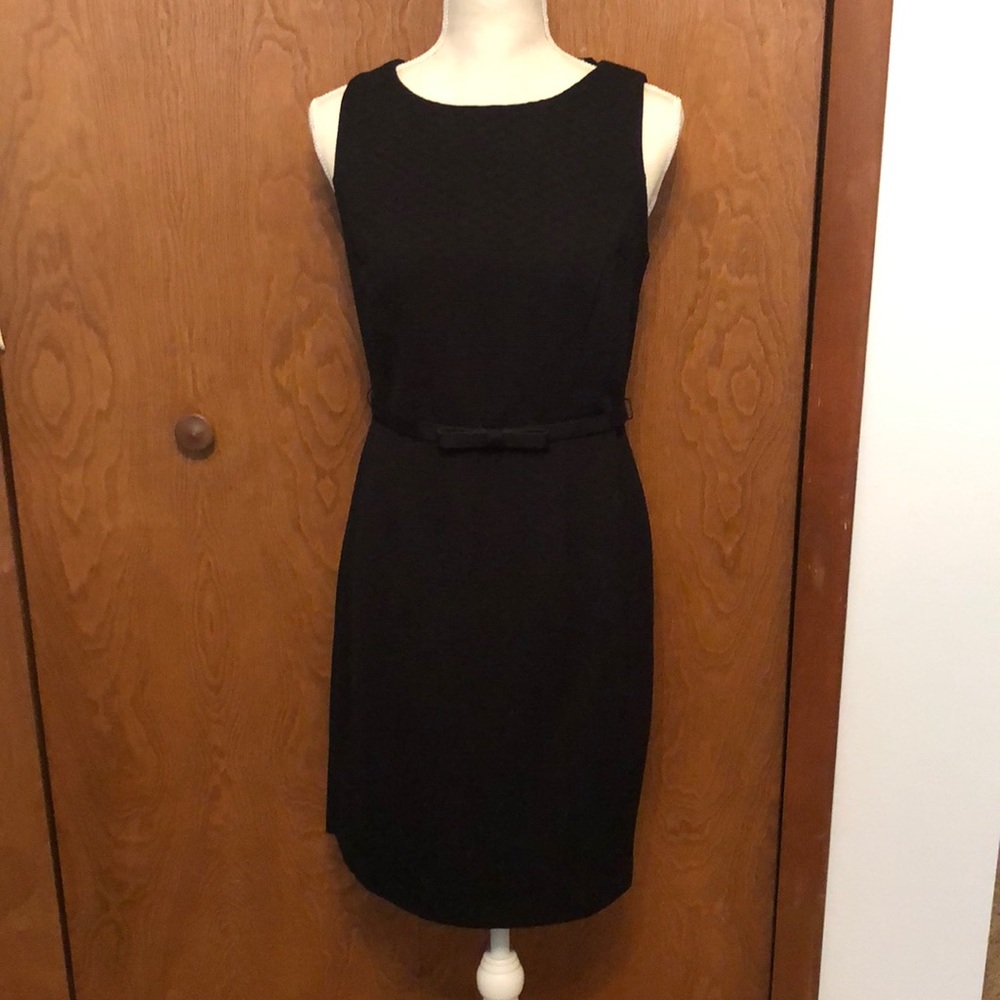 Black sleeveless dress with patterned, zip-up back and bow belt.